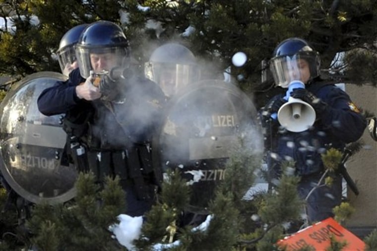 Police fire rubber bullets at protestors outside the meeting hall of the World Economic Forum in Davos, Switzerland, on Saturday. More than two dozen senior officials from key economies will try to agree on whether to send a political signal that a new global trade deal can, at last, be completed this year. 